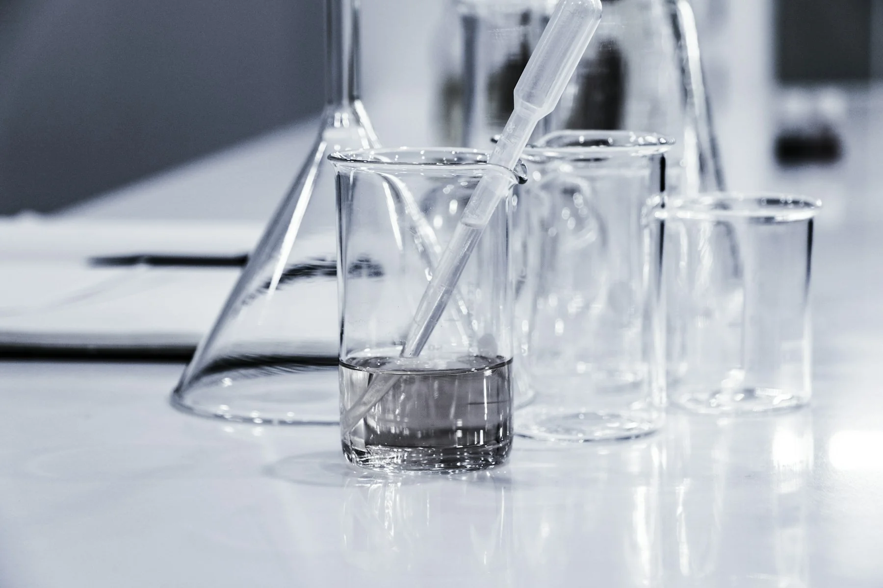Laboratory beakers, a conical flask and a pipette on a workbench